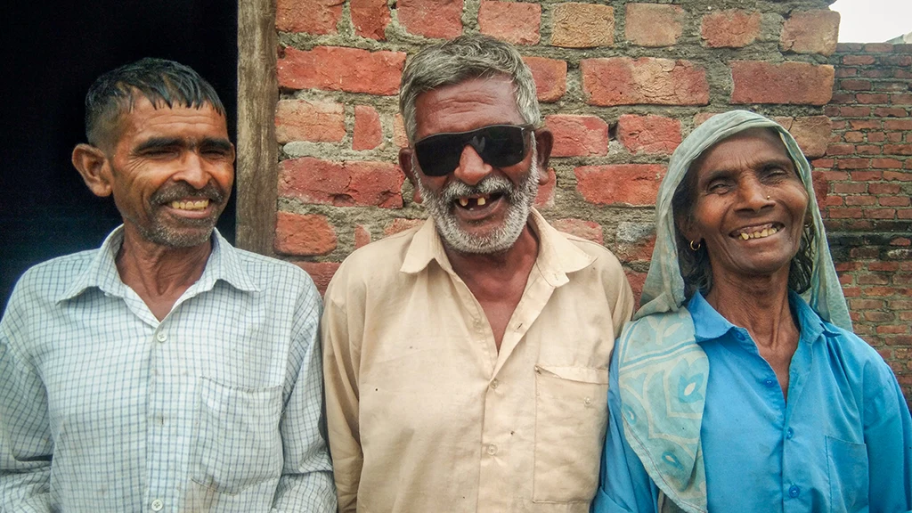Harprasad beams from between two family members