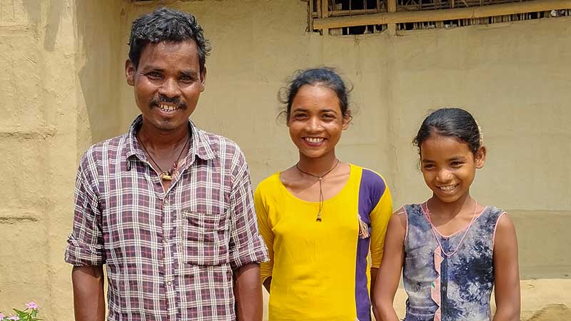 Man stands with his two daughters beside him