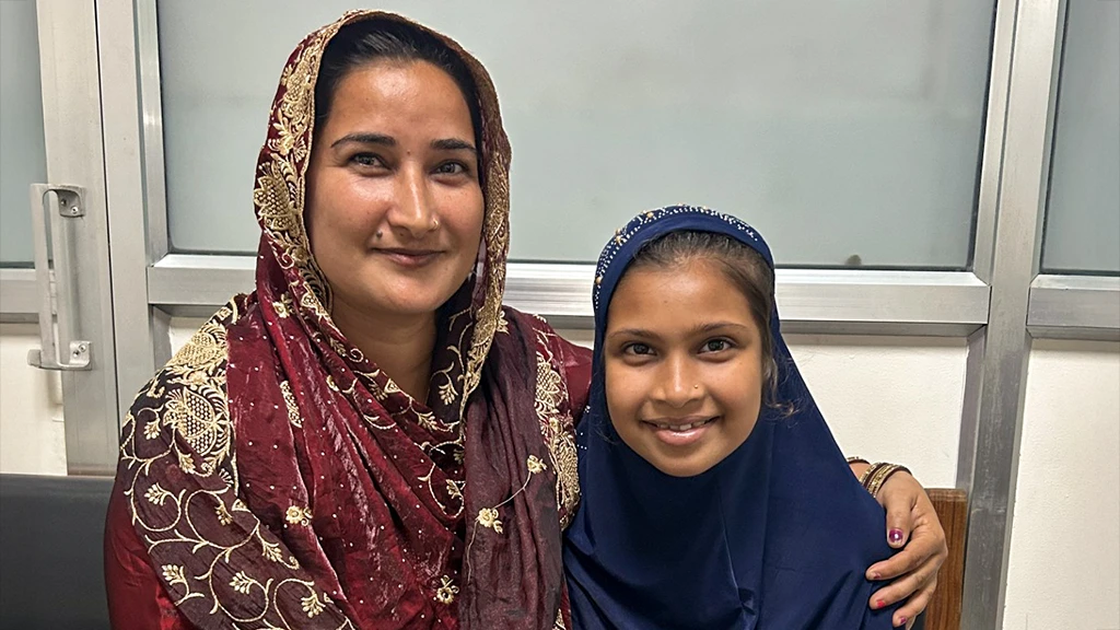 A woman and girl sit close together