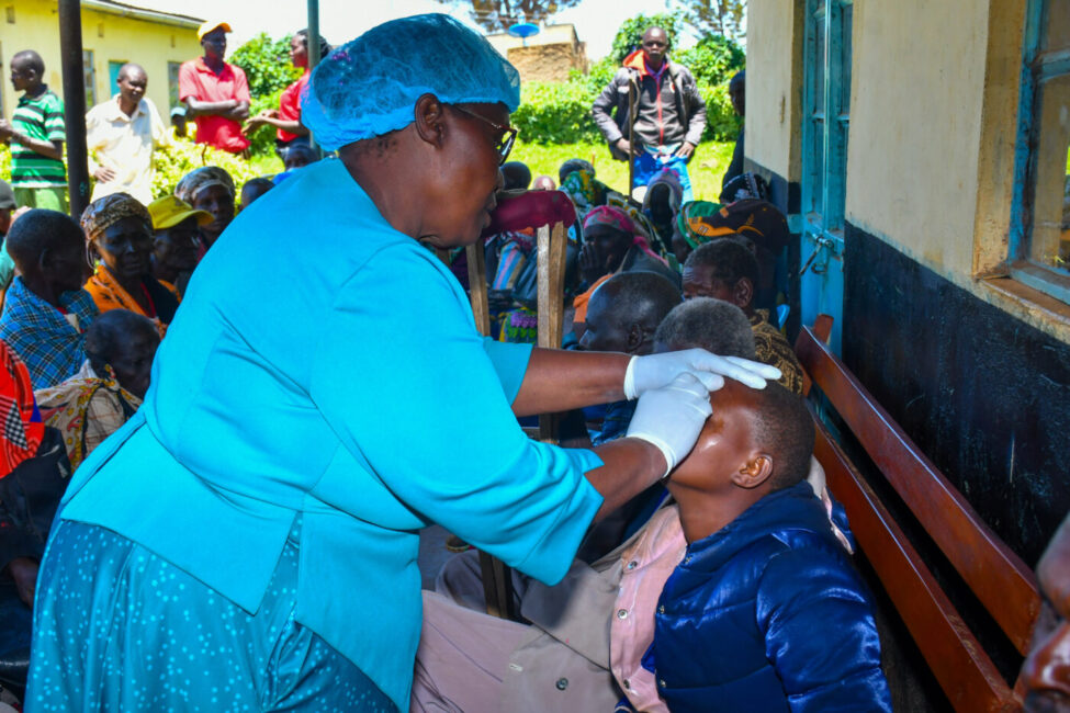 Photo from community eye screening camp as a healthcare personnel attends to the people.|A construction site with people wearing safety gear|Operation Eyesight staff and dignitaries cut the ribbon for the official opening of the Eye Unit at Maamba General Hospital.|Operation Eyesight staff and dignitaries cut the ribbon for the official opening of the Eye Unit at Maamba General Hospital.|A patient receives a vision test during a community eye health screening|Students wear heart-shaped eyeglasses and hold World Sight Day banners that say "Love Your Eyes"|A group of people sit facing a stage as their village is declared avoidable blindness-free
