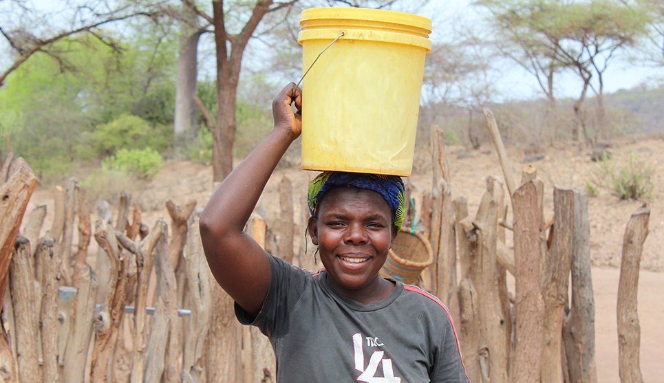 Woman holding bucket of water over her head