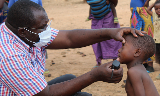 A man looks into the eyes of a little boy|A man looks into the eyes of a girl using flashlight