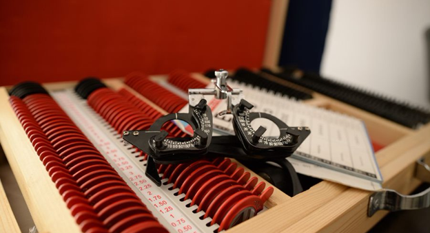 Trial lens set with adjustable frame|A health workers talks to a student as he gets his eye tested at school|A young man