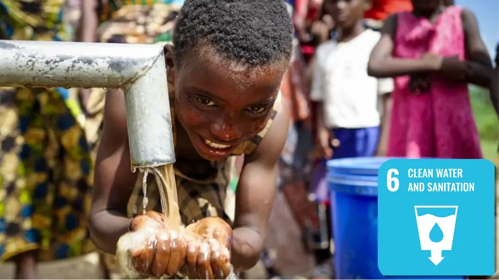 A child washes her face at an outdoor water pump.|||||A child washes her face at an outdoor water pump.||
