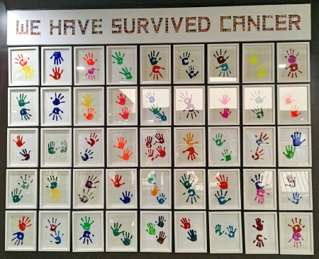 Wall of children's hand prints who were given life-saving eye cancer treatment by Operation Eyesight|Kenyan child receives life-saving canacer treatment through Operation Eyesight.|Indian boy receives life-saving eye cancer treatment through Operation Eyesight