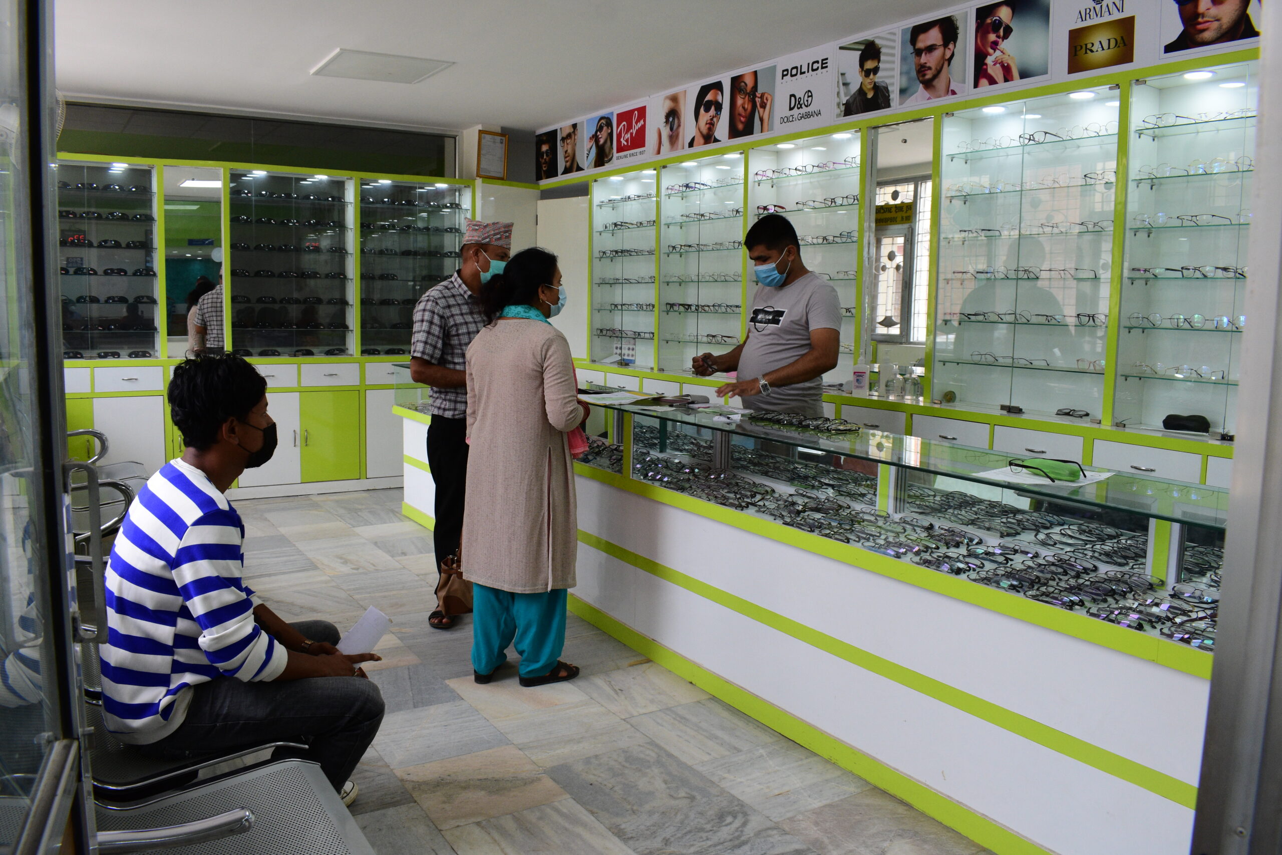 A couple purchasing glasses at an optical shop.|Woman teaching a group of people health education in Nepal.