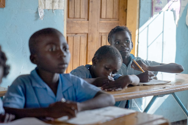 Students in their classroom takes notes|Two female students wearing school uniforms walk away from the camera